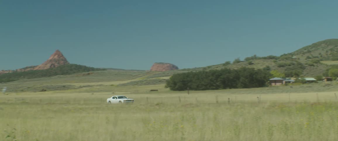White sports car driving throuhg the countryside