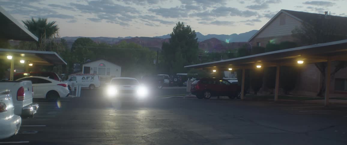 White sports car parking on a hotel in a small town
