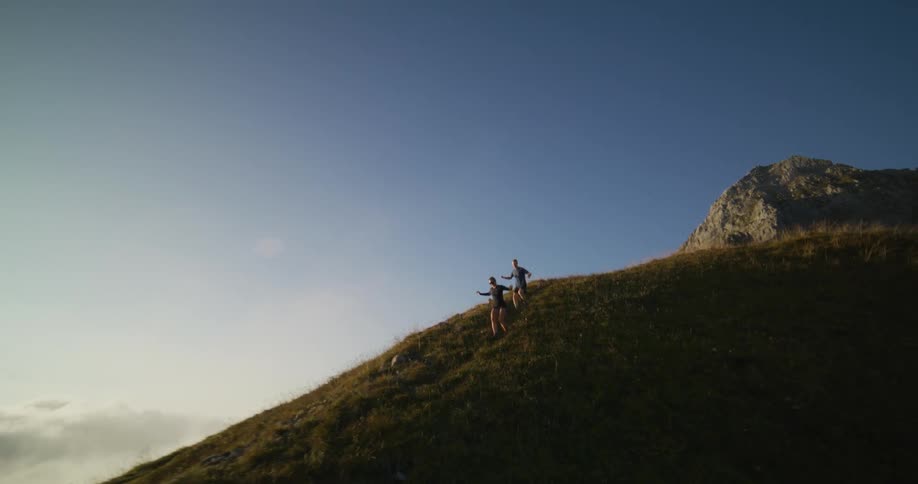 Two people running down a hill