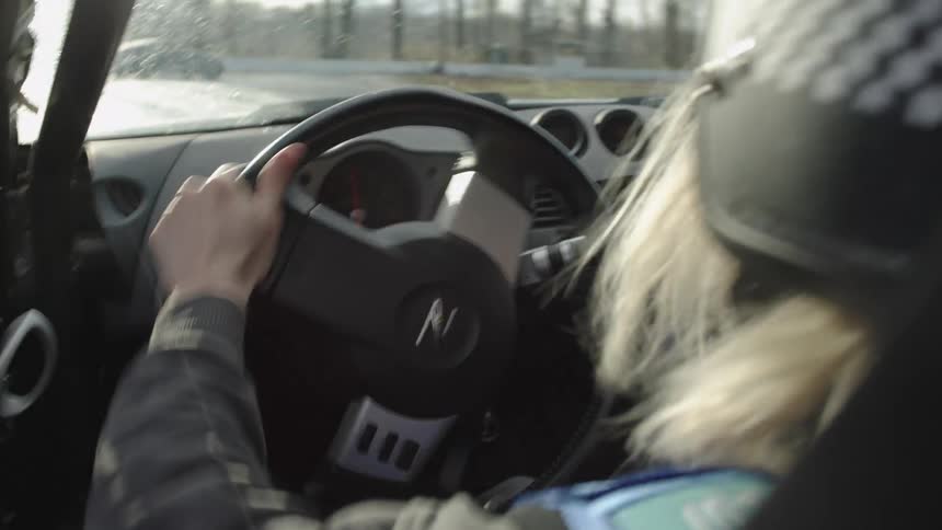 A woman drifting in a car race at midday