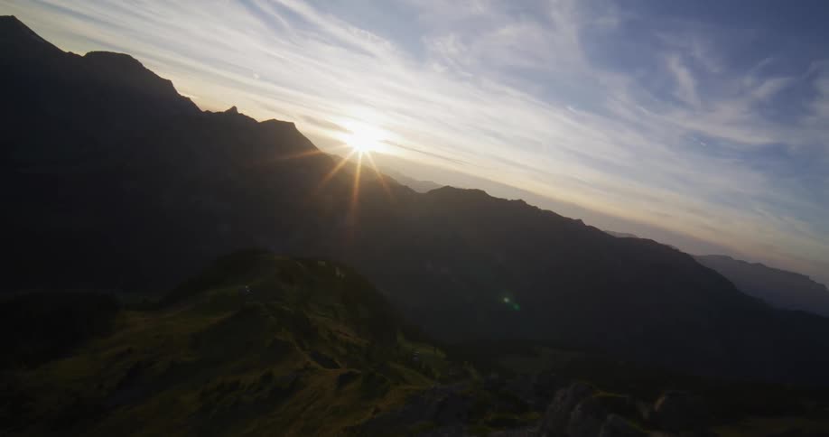 Panorama of rocks and peaks with the sun on the horizon