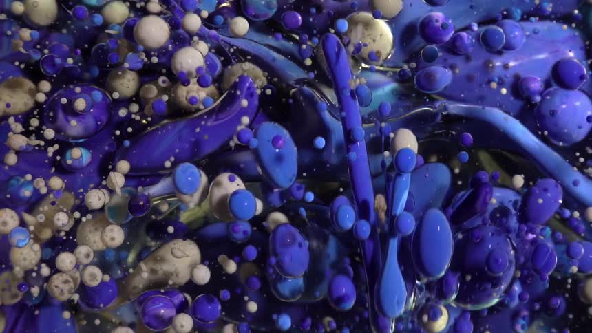 A blue and gray liquid moving randomly and forming several bubbles