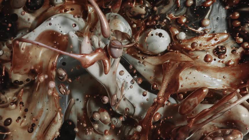 A liquid with copper colors forming abstract bubbles and shapes