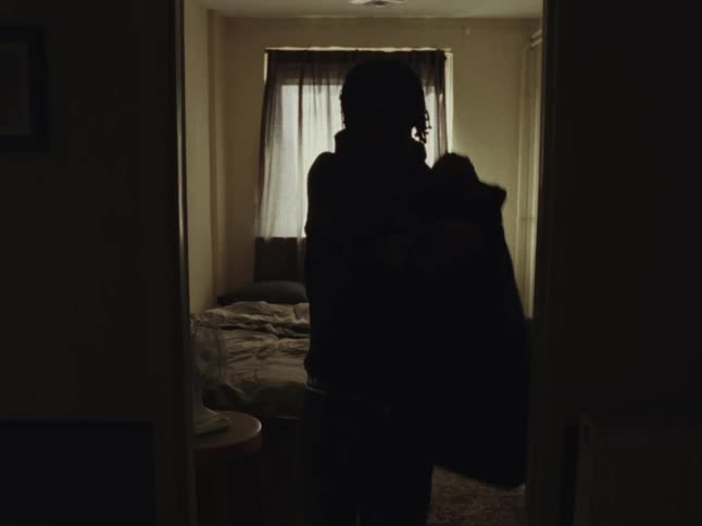 Young man puts a jacket before leaving the apartment