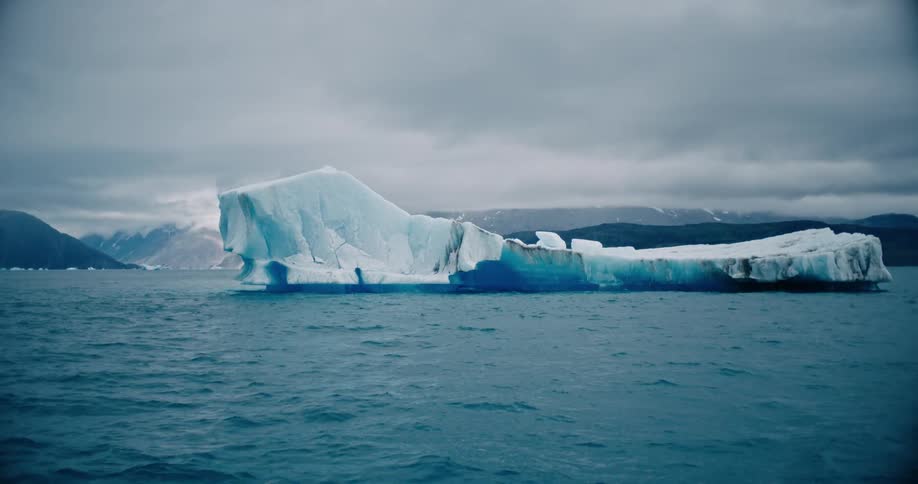 A blue iceberg floating in the arctic ocean