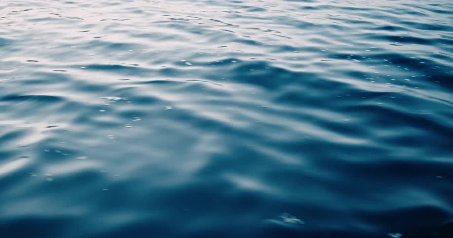 Closeup of the calm waves of the sea with sunlight reflection