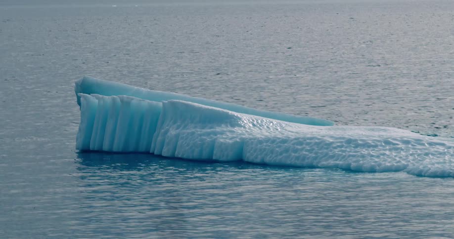 A melting iceberg floats in arctic water