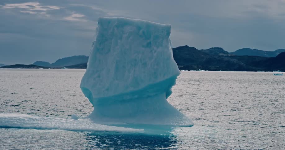 A melting iceberg floats of the arctic coast