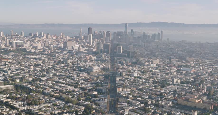 Aerial panoramic either side of the main highway through san francisco ending at the hazy downtown skyline on a bright day