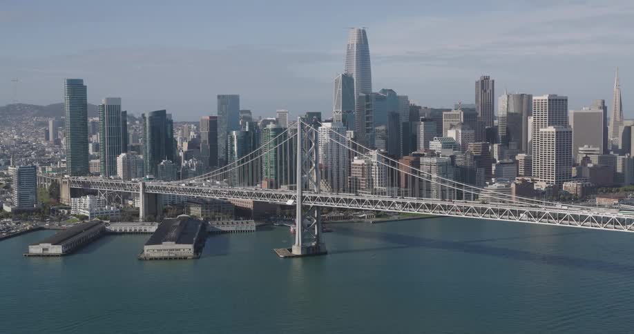Aerial panorama of a bridge over the sea facing a metropolis with skyscrapers