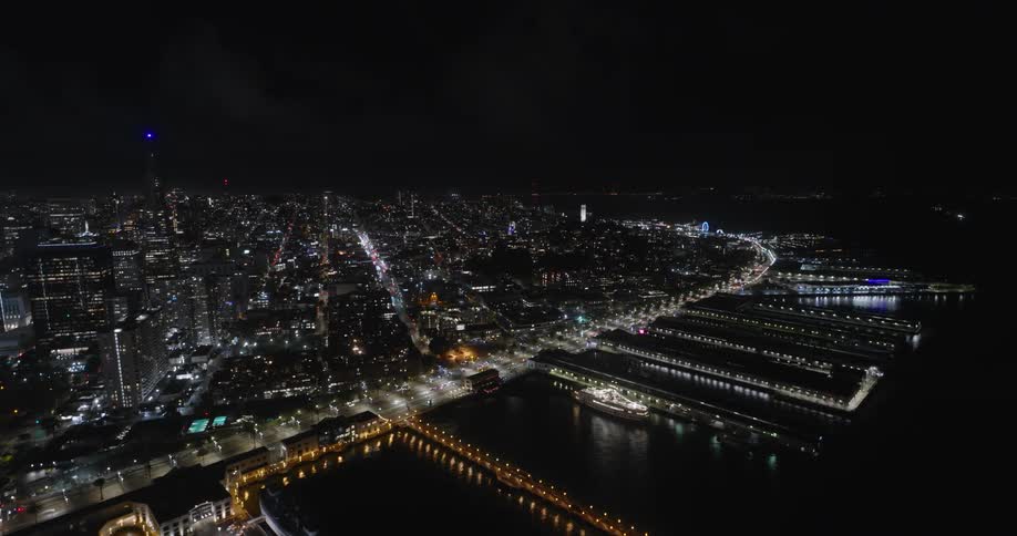 An aerial view of a city at night with several lights on