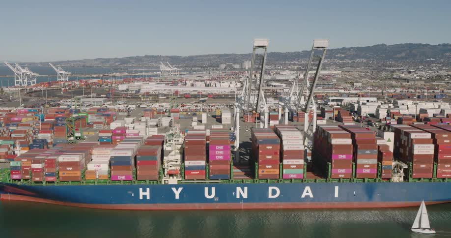 A large cargo ship loaded with containers on top of the water at a dock