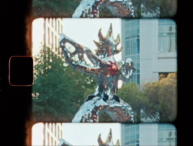 Shiny metal sculpture in the city caught on vintage film