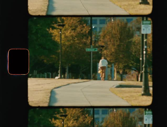 A person walking through a park courtyard during the day