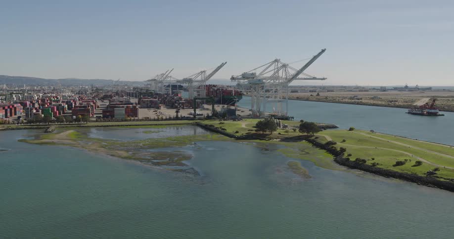 Aerial view of waterfront port with shipping containers and cranes