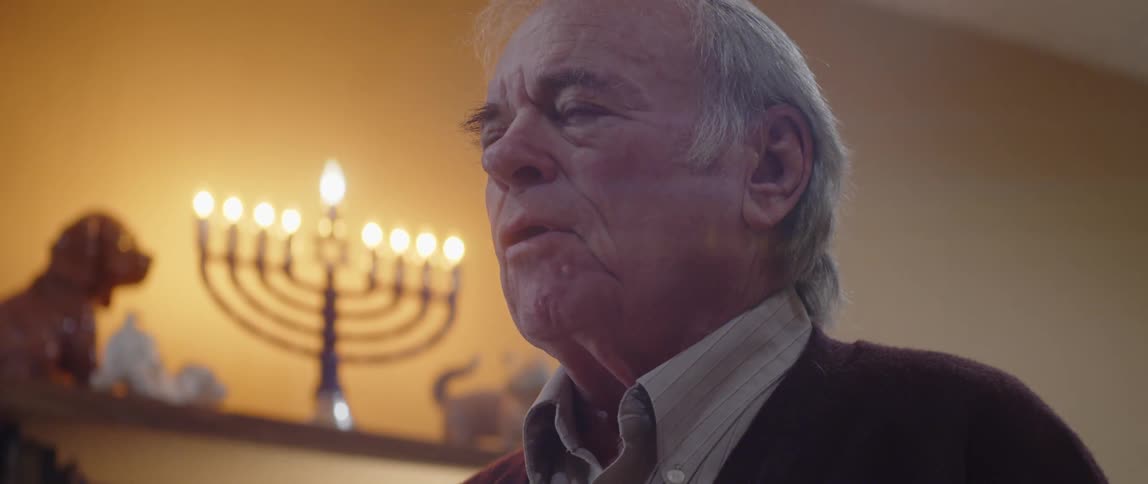 A man is saying a prayer near hanukkah candles