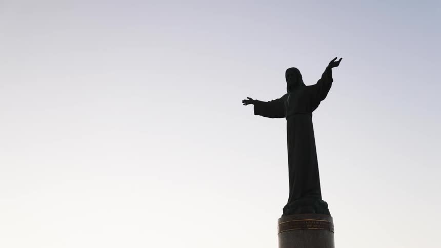 View of a statue with open hands under a cloudy sky