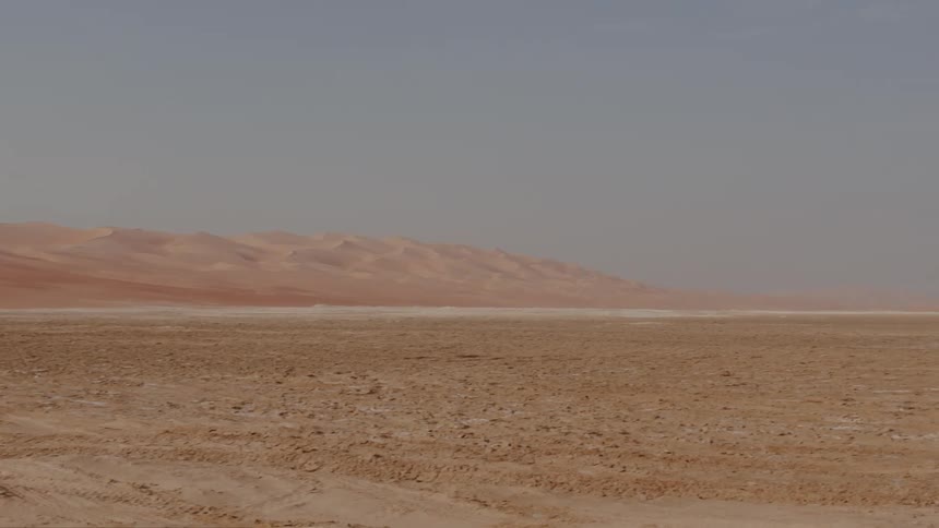 In Abu Dhabi a view of sand dunes drifted across the desert under a hazy sky