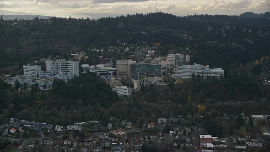 Aerial panorama of an urban city amidst mountains on a cloudy day