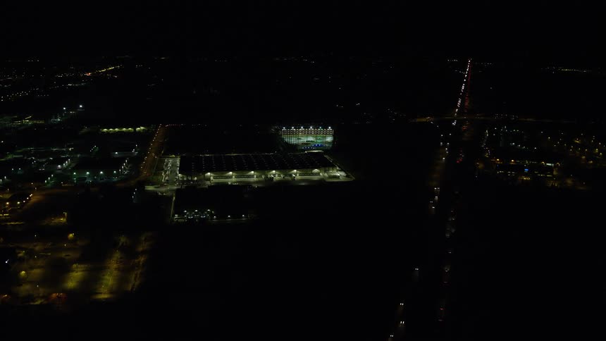 Aerial panorama of a metropolis with a central highway at night