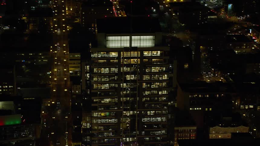 A city view in the middle of the night as light shines from the building