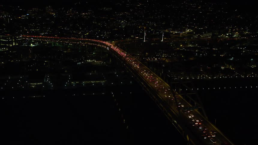 Aerial view of a suspension bridge near a city at night