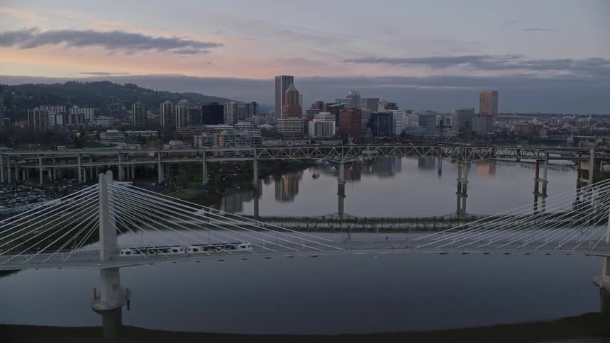 Aerial view of bridges over a river through the city at evening