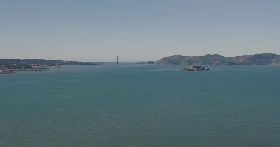 Panorama of a sea with a mountain range around it under a morning sky