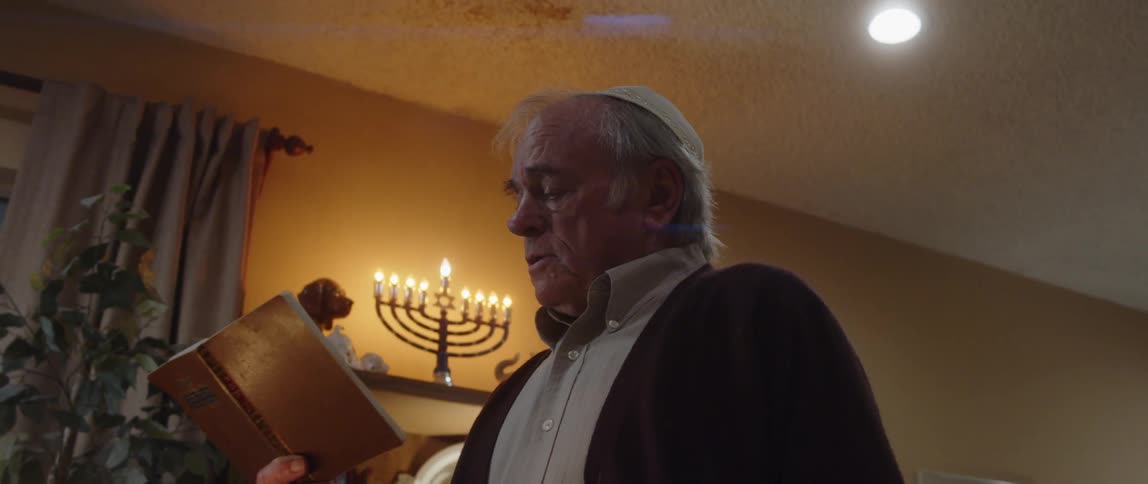 Elderly person in a suit standing and reading a bible