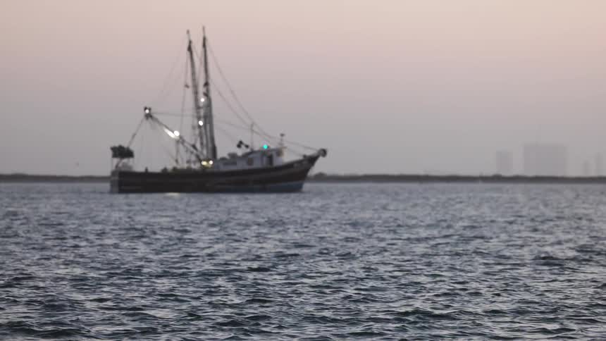 A small fishing boat in the ocean at evening