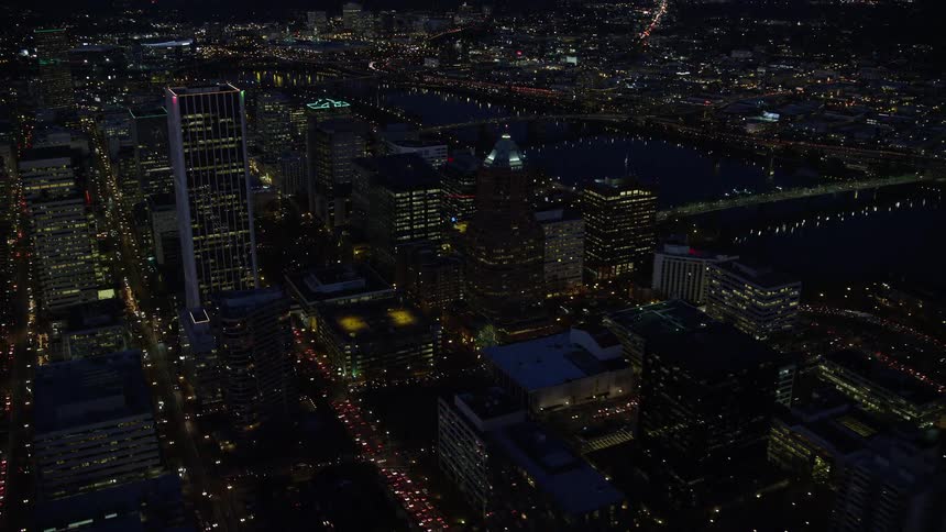 Aerial view of illuminated riverfront buildings and bridges in the city