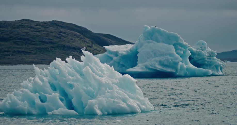Melting icebergs float off the arctic coast