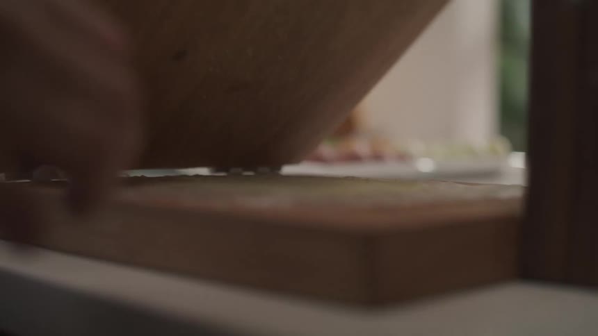 Hand of a woman closing a wooden accessory with a leaf inside