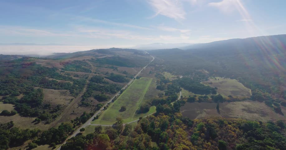 A highway traversing a rural countryside surrounded by a forested landscape