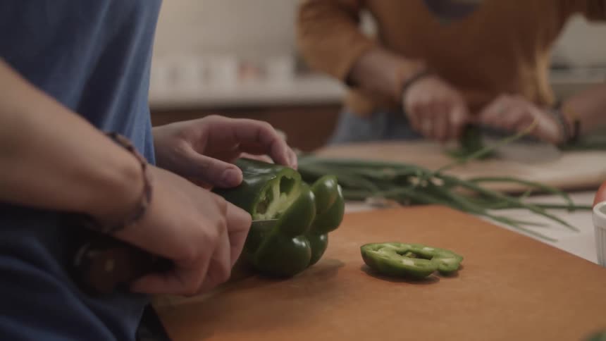 Two people are cutting vegetables
