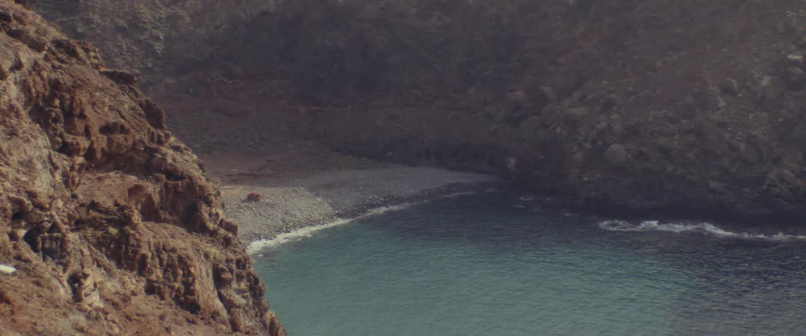 Aerial of a deserted beach surrounded by mountains