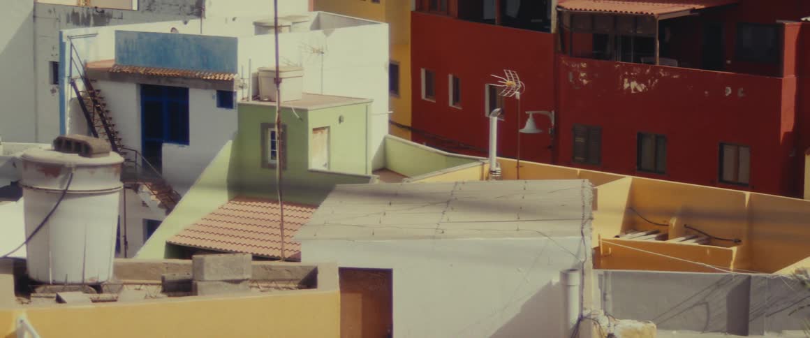 Antennas and other machinery top apartments of various colors in a residential neighborhood