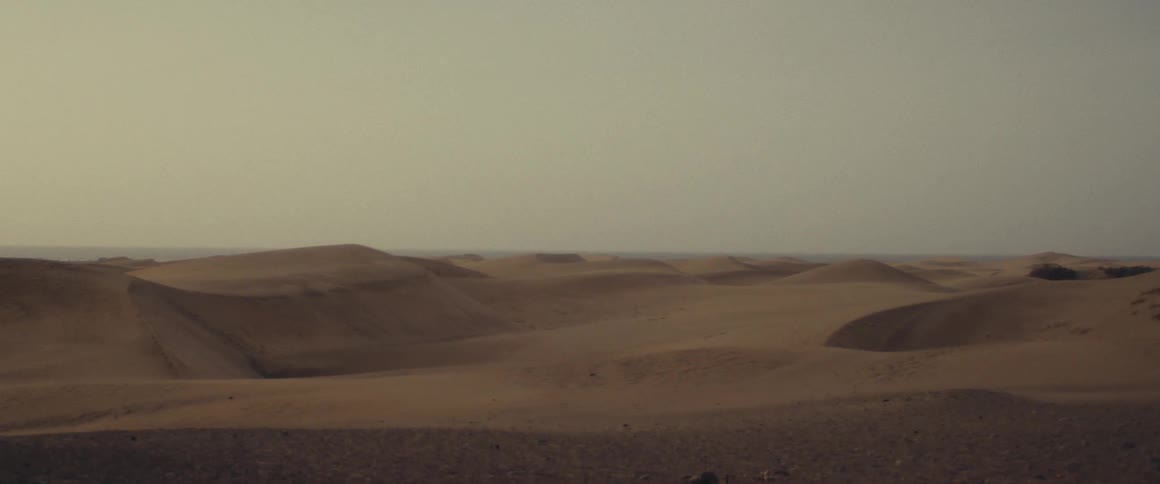 The sun shines upon drifted dunes in the desert