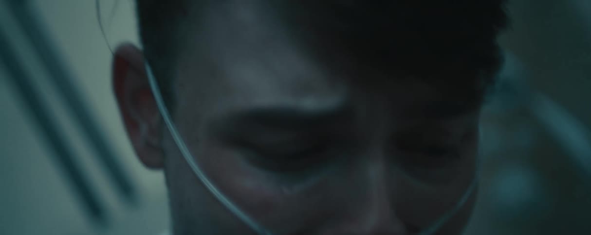 A sad crying man wearing a breathing aid