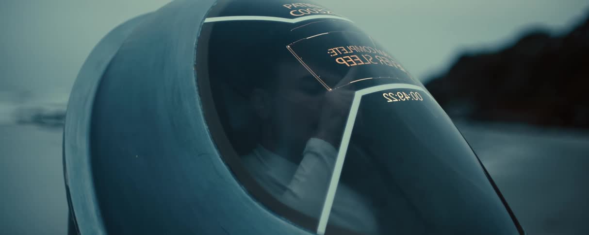 Man inside a capsule in the middle of a beach trying to escape