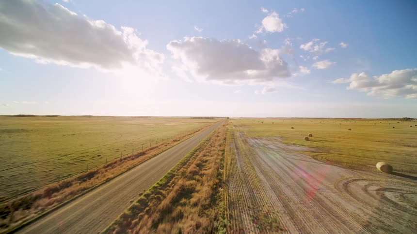 A trail runs through the long flat field