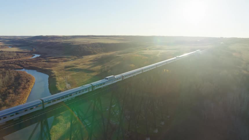 Aerial panorama of a train passing on a suspended railway over a lake