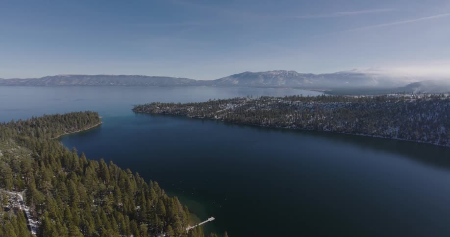 A small bay is surrounded by heavily forested coastlines
