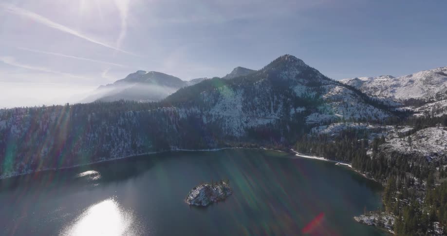 Aerial view of a small lake surrounded by snowy mountains