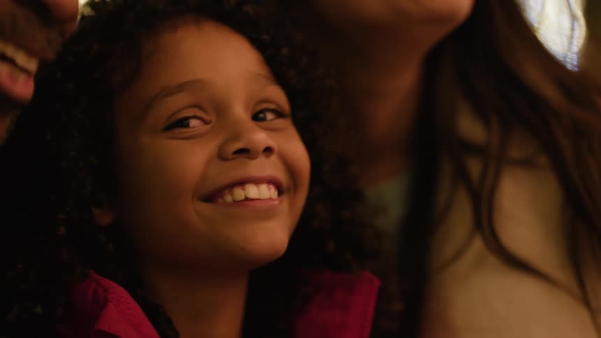 Portrait of a smiling family outdoors at night in a festive city setting
