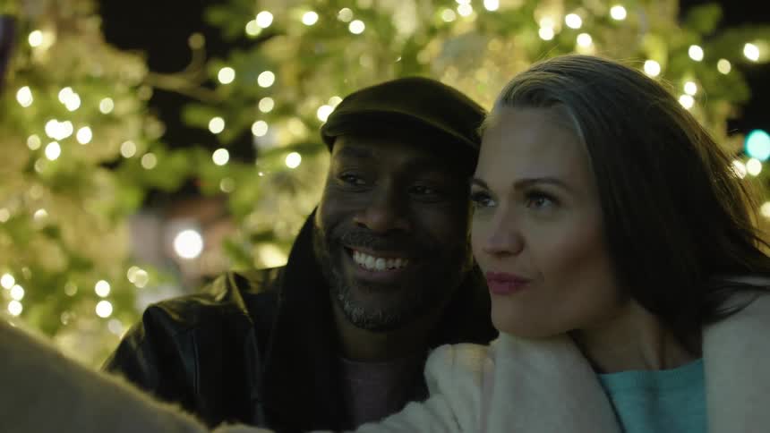 Couple kiss while taking a selfie at christmas