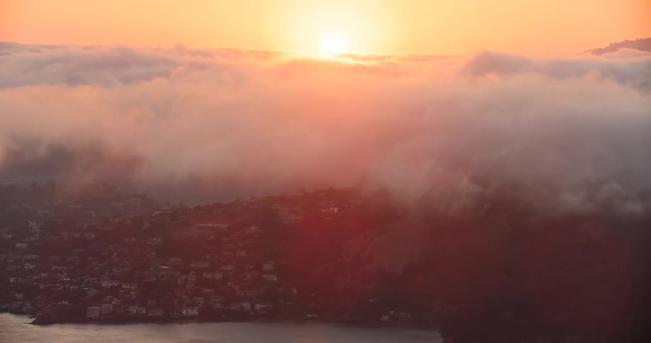 Clouds hover over the San Francisco Bay as the sun sets