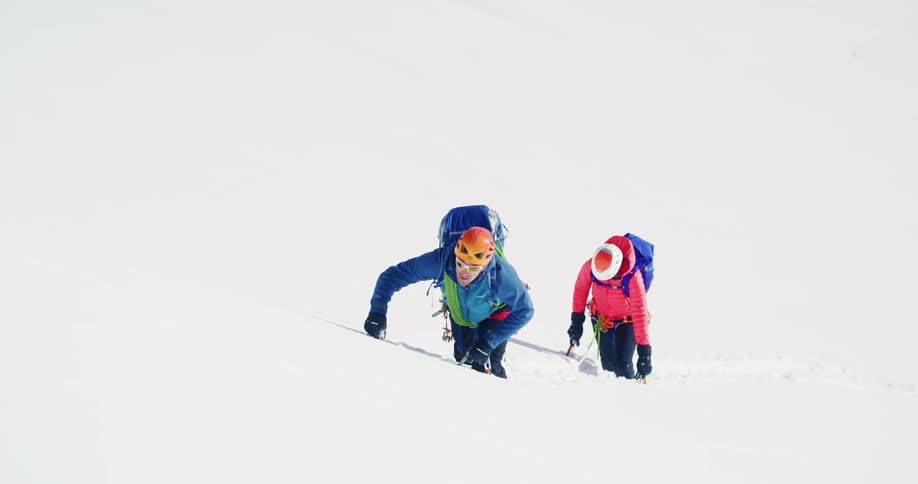 Two people climbing a snowcovered hill