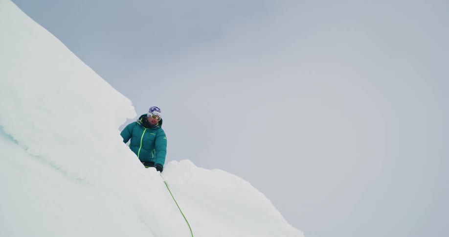 Bird flies over a mountaineer pulling a rope