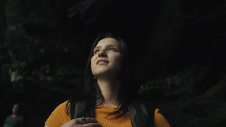 A woman hiking stops and sticks her tongue out